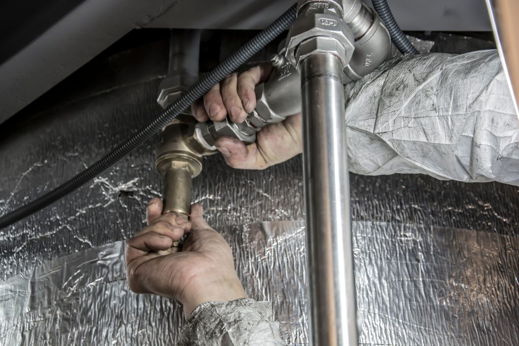 Professional plumber fixing a broken toilet facet